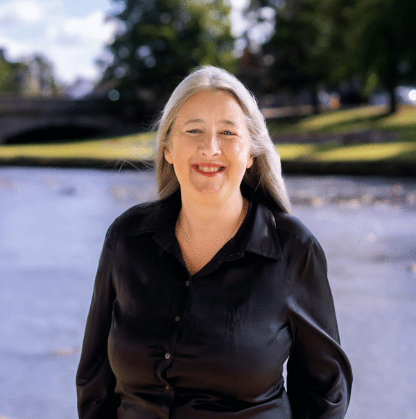 Garden designer Lynn Hill stands before the blue waters of the river Esk in East Lothian.